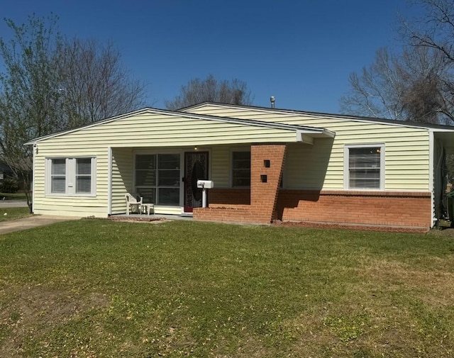 view of front of house featuring brick siding and a front yard