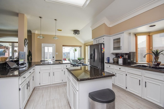 kitchen with a sink, fridge with ice dispenser, a peninsula, and white cabinetry