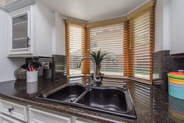 kitchen with white cabinetry, glass insert cabinets, a wealth of natural light, and a sink