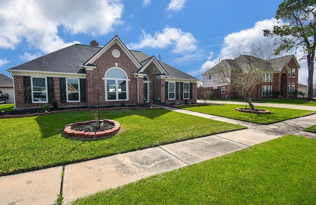 view of front of home featuring a front yard, brick siding, and roof with shingles