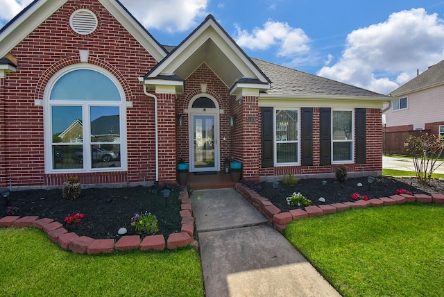 view of front of property featuring brick siding and a front lawn