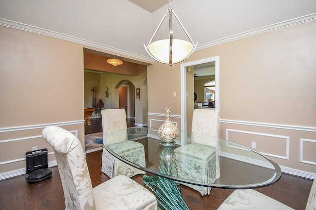 dining area with arched walkways, wood finished floors, wainscoting, and ornamental molding