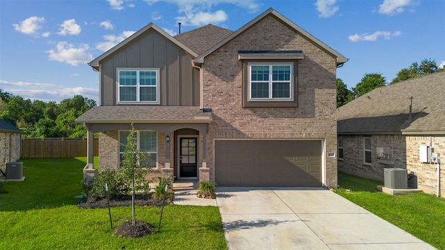 view of front of property with driveway, board and batten siding, an attached garage, a front yard, and brick siding