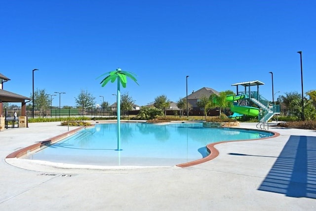 community pool with a water slide and fence