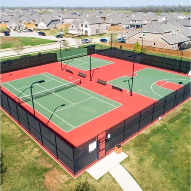 exterior space with a residential view, community basketball court, a tennis court, and fence