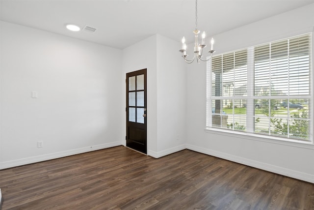 unfurnished room with dark wood finished floors, baseboards, visible vents, and a chandelier