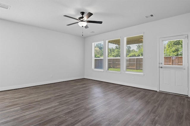 spare room with visible vents, a healthy amount of sunlight, and dark wood-style flooring