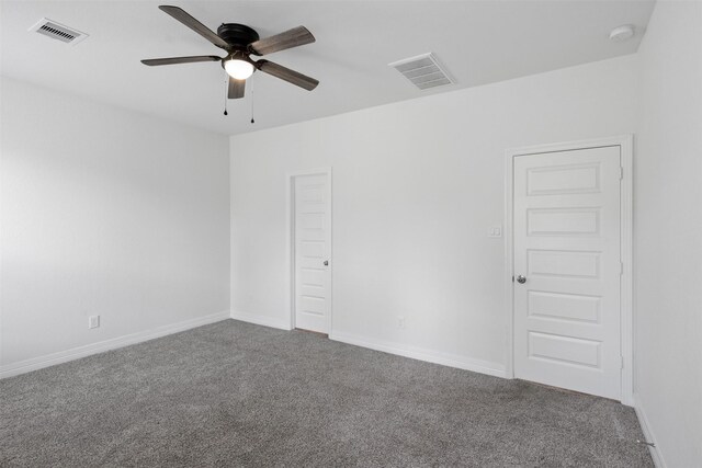 unfurnished room with carpet, visible vents, and ceiling fan