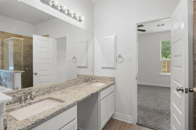 full bathroom featuring a sink, visible vents, double vanity, and a shower stall