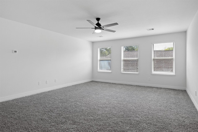 empty room with visible vents, baseboards, a ceiling fan, and carpet flooring