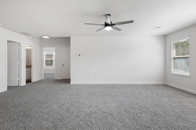 unfurnished room featuring a wealth of natural light, a ceiling fan, and carpet