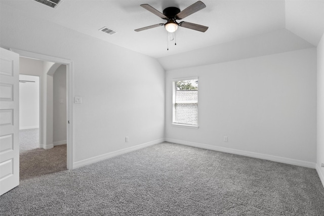 spare room featuring visible vents, ceiling fan, carpet floors, vaulted ceiling, and arched walkways