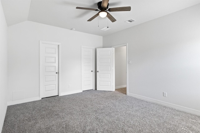 unfurnished bedroom with visible vents, lofted ceiling, baseboards, and carpet floors