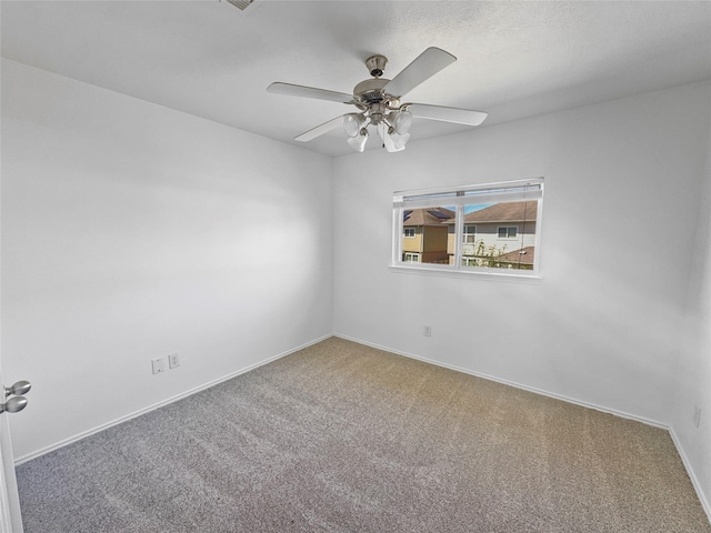 carpeted empty room featuring baseboards and ceiling fan