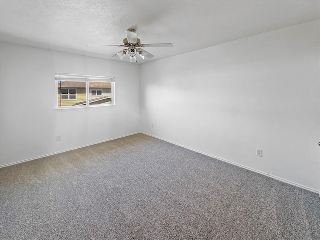 spare room with carpet, a ceiling fan, baseboards, and a textured ceiling