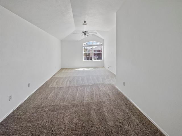 carpeted empty room featuring vaulted ceiling and ceiling fan