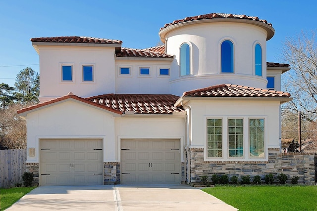 mediterranean / spanish-style house featuring a tiled roof, stone siding, driveway, and stucco siding