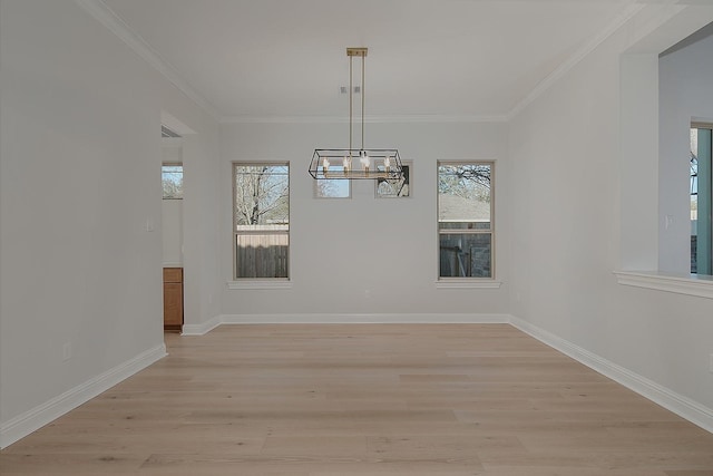 unfurnished dining area featuring baseboards, an inviting chandelier, ornamental molding, and light wood finished floors