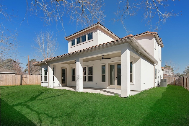 back of property with a fenced backyard, a lawn, a patio, and a ceiling fan