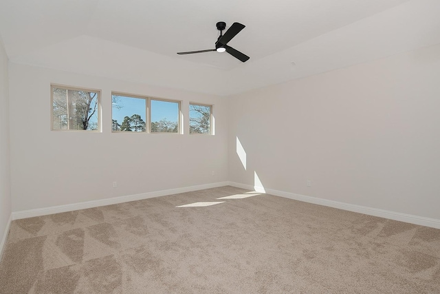 spare room featuring ceiling fan, baseboards, a raised ceiling, and carpet