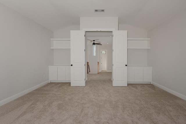 unfurnished bedroom featuring visible vents, lofted ceiling, carpet, and baseboards