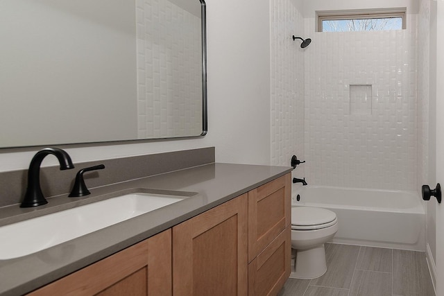 bathroom featuring toilet, vanity, and bathtub / shower combination