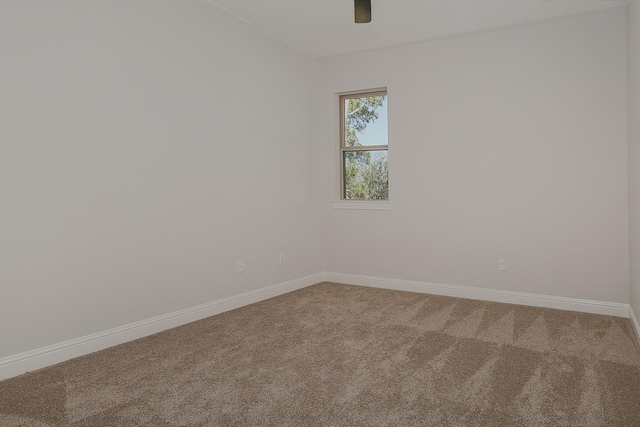 carpeted empty room with baseboards and a ceiling fan