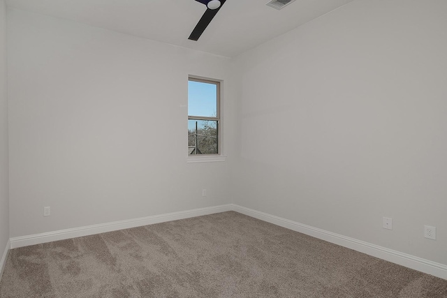 carpeted spare room featuring baseboards and ceiling fan