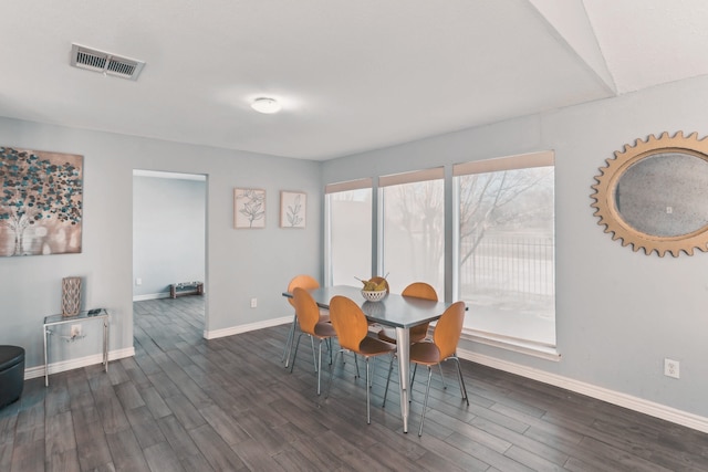 dining area featuring dark wood-type flooring, baseboards, and visible vents