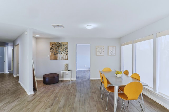 dining area with visible vents, baseboards, and light wood-style floors