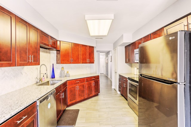 kitchen featuring a sink, stainless steel appliances, reddish brown cabinets, and decorative backsplash