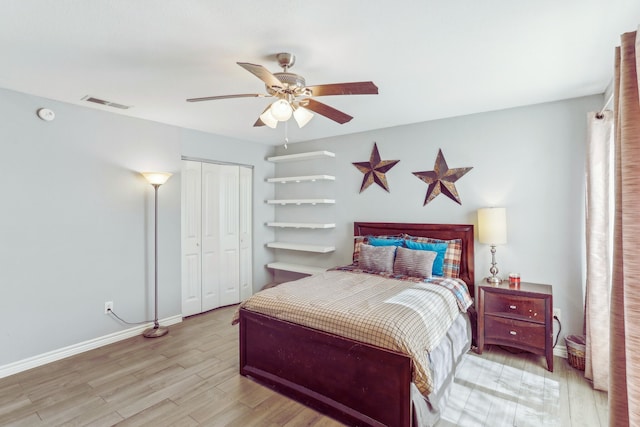 bedroom featuring a closet, visible vents, baseboards, and wood finished floors