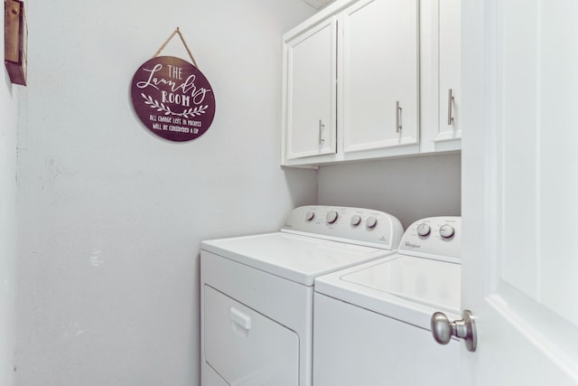 clothes washing area featuring cabinet space and washing machine and clothes dryer