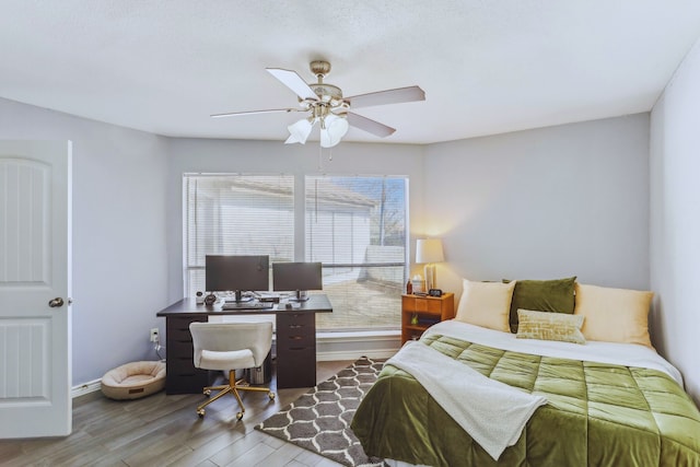 bedroom with wood finished floors, baseboards, and ceiling fan