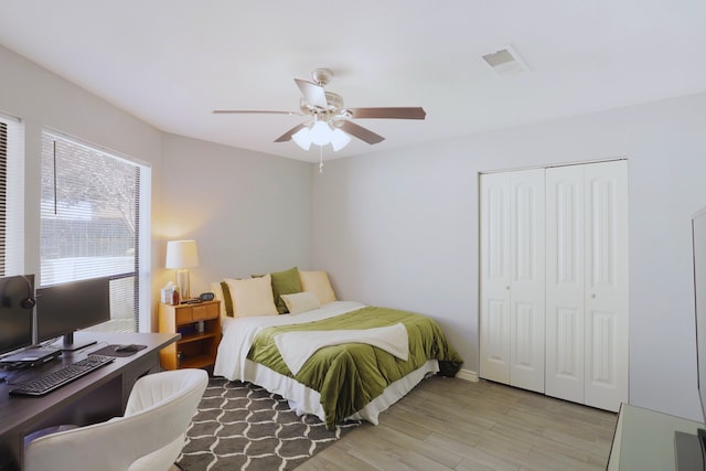 bedroom featuring visible vents, a closet, light wood finished floors, and ceiling fan