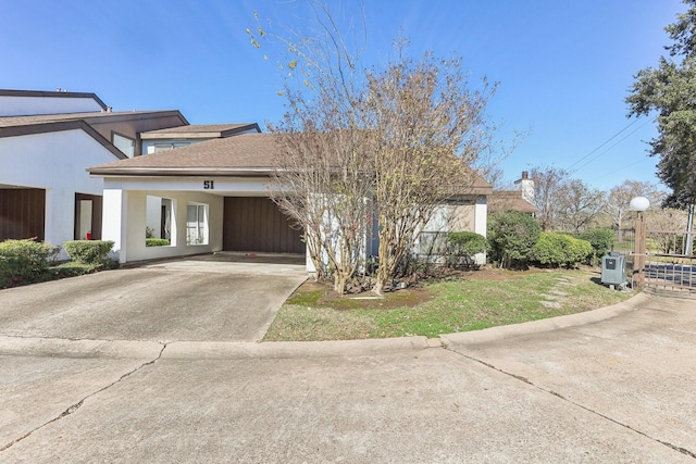 view of front of home with concrete driveway, a front lawn, roof with shingles, and stucco siding