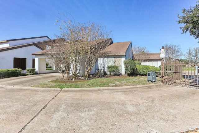 exterior space with a carport, fence, driveway, and stucco siding