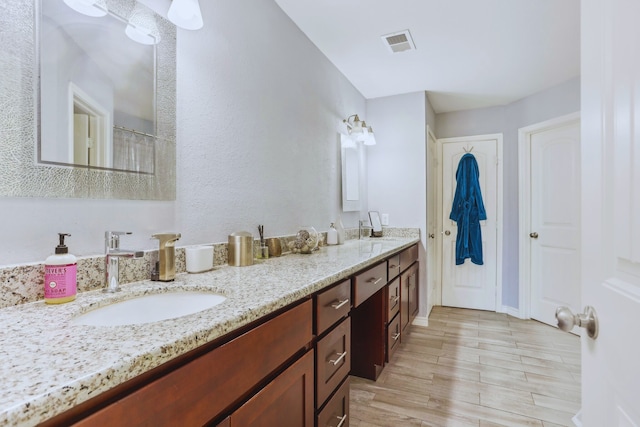 bathroom featuring a shower with shower curtain, baseboards, visible vents, double vanity, and a sink