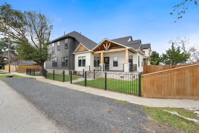 view of front of house with a fenced front yard, a front yard, and a gate