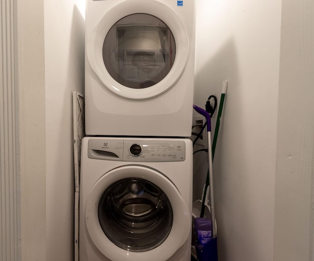 clothes washing area with stacked washer / drying machine and laundry area