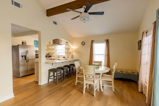 dining space featuring visible vents, vaulted ceiling with beams, light wood-style floors, and a ceiling fan