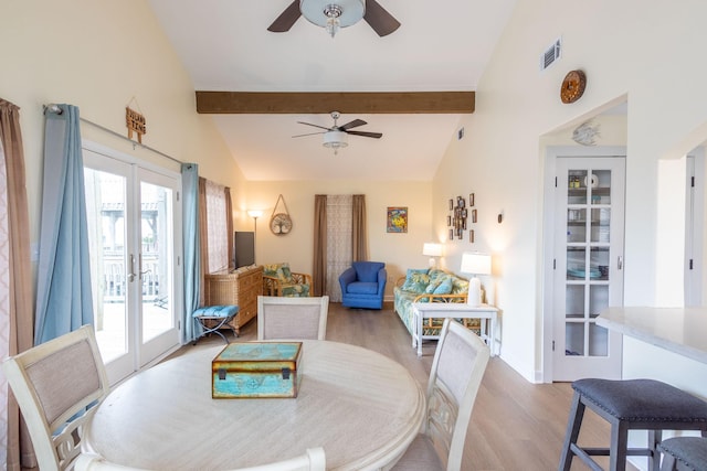 dining room featuring visible vents, light wood-style floors, beamed ceiling, and ceiling fan