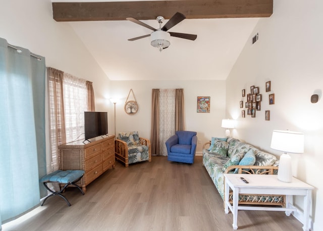 living area with visible vents, beam ceiling, high vaulted ceiling, light wood-style flooring, and a ceiling fan