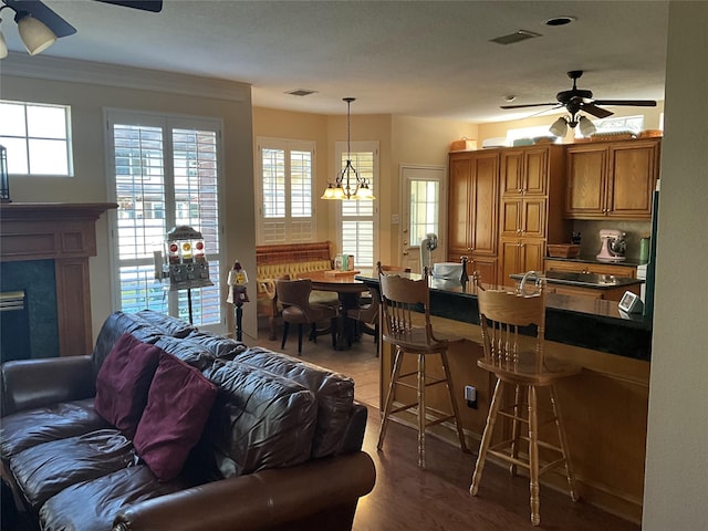 living area with a ceiling fan, visible vents, and a high end fireplace