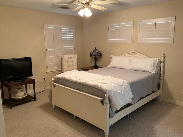 bedroom with visible vents, light carpet, baseboards, and ceiling fan