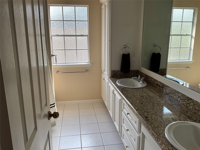 full bathroom featuring tile patterned flooring, double vanity, plenty of natural light, and a sink