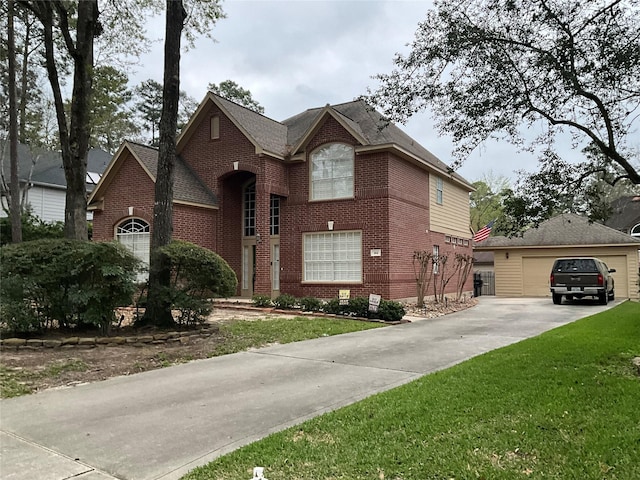 view of front of house featuring brick siding, an outbuilding, and a front lawn