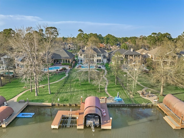 view of dock with a lawn, a water view, and a residential view