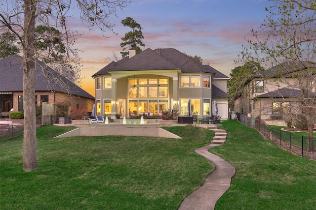 back of property with a patio, fence, roof with shingles, a chimney, and a lawn