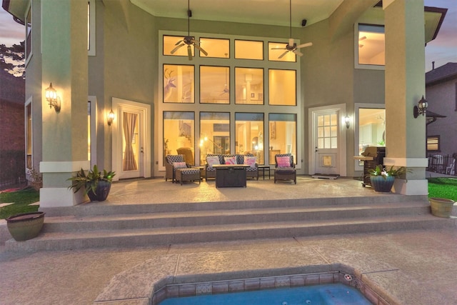 rear view of property with ceiling fan, a patio, an outdoor hangout area, and stucco siding